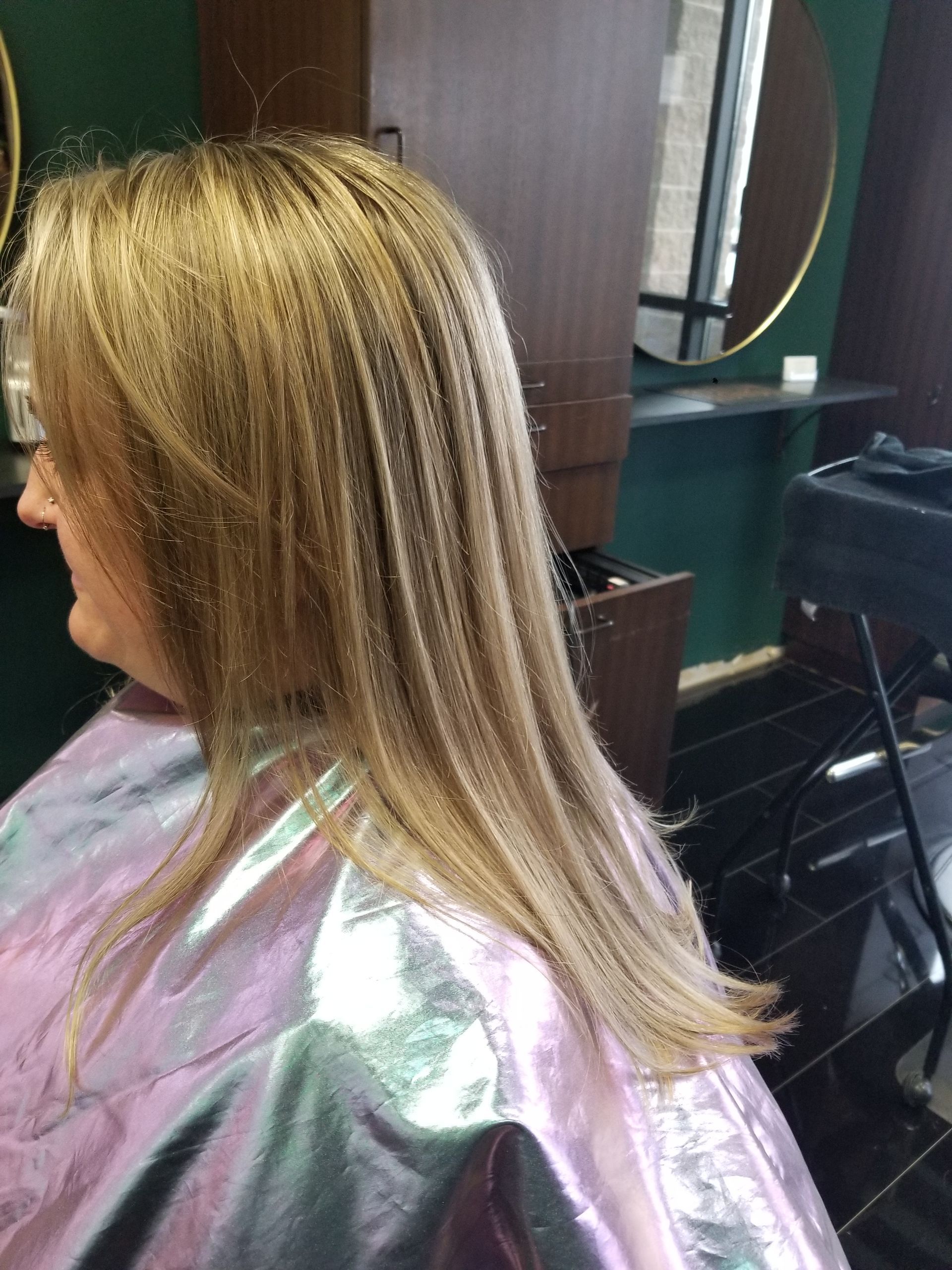 A woman is getting her hair cut in a salon.