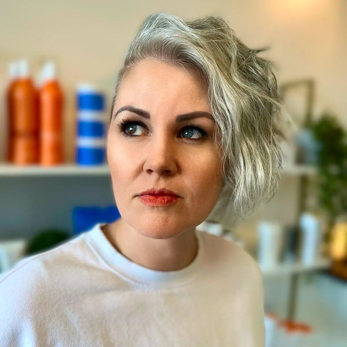 A woman with gray hair is wearing a white shirt