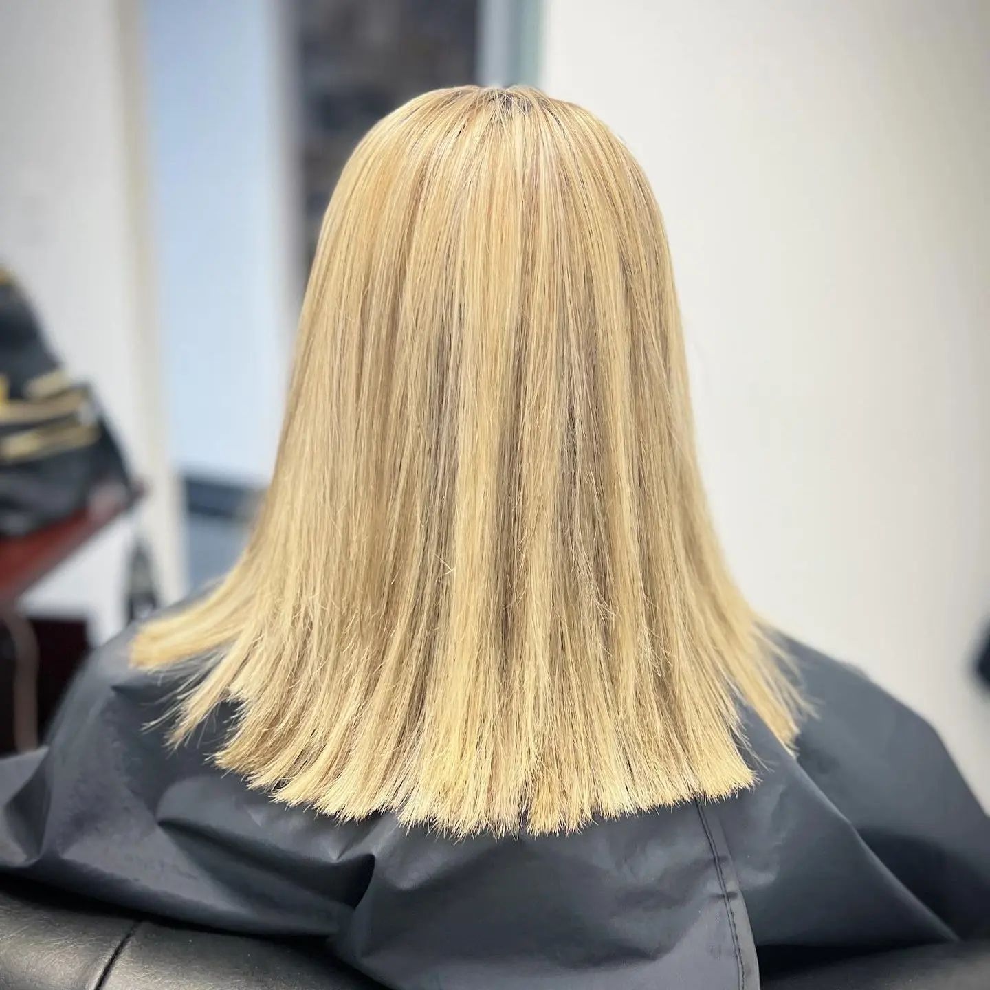 A woman with blonde hair is sitting in a chair