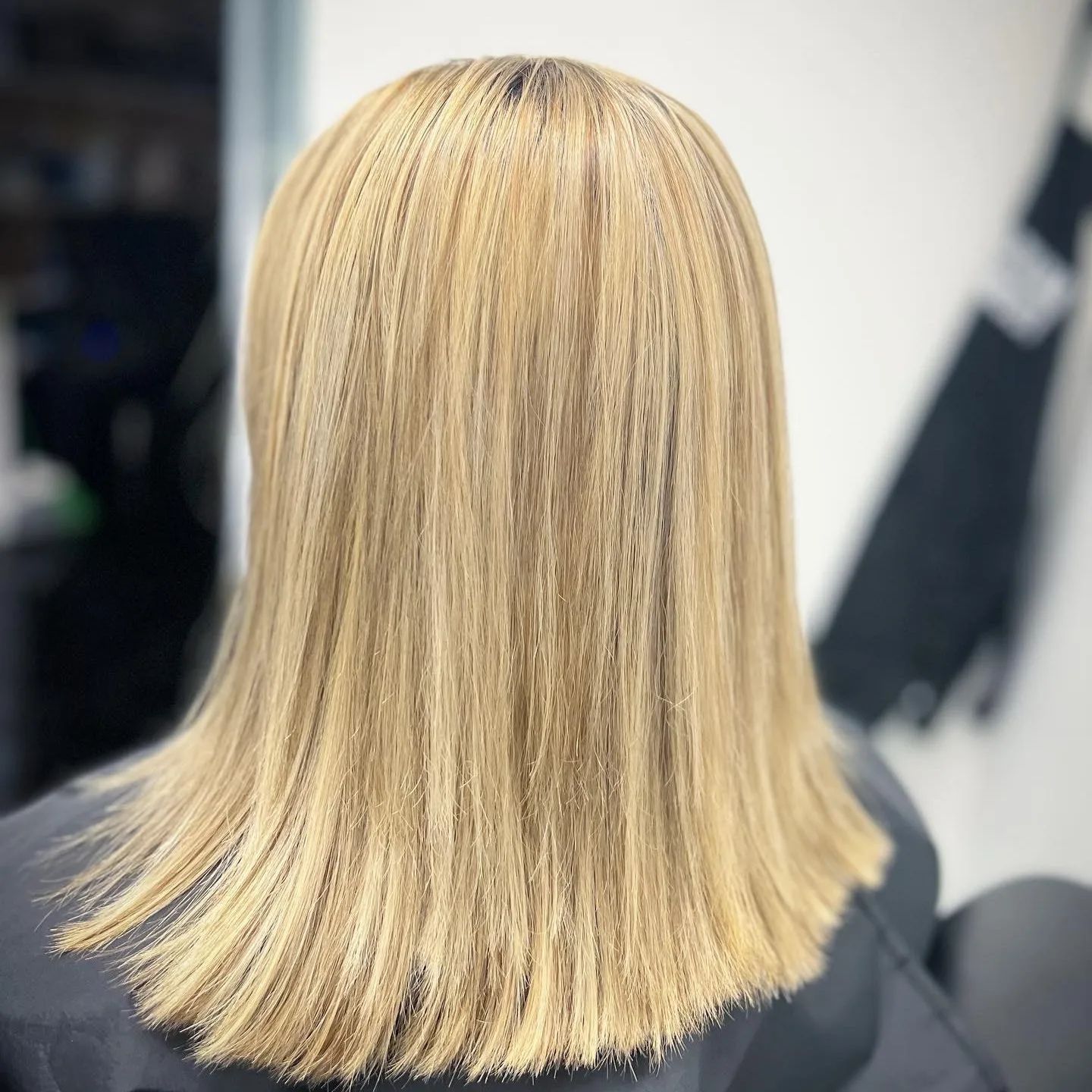 A woman with blonde hair is sitting in a chair.