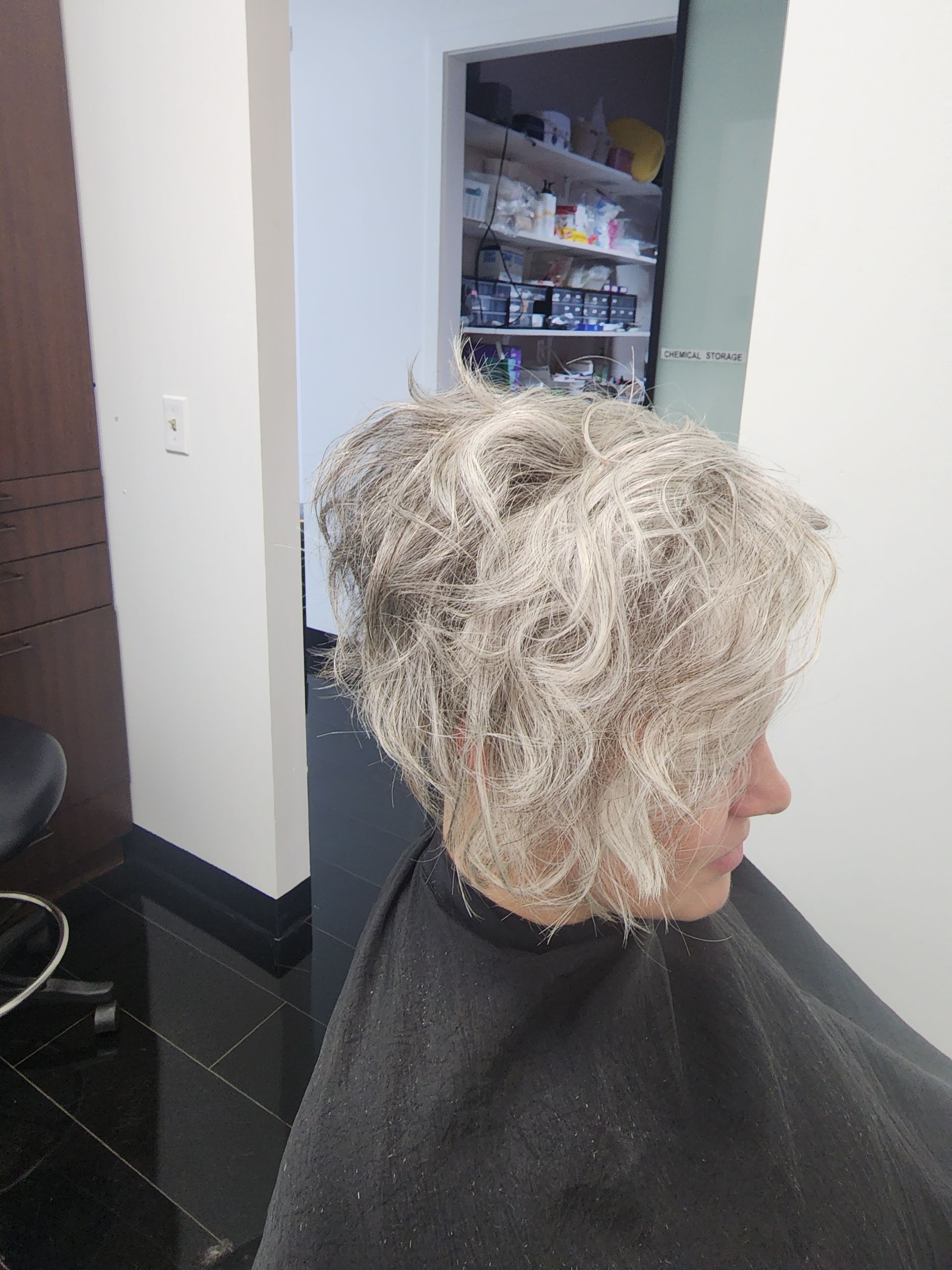 A woman is getting her hair cut in a salon