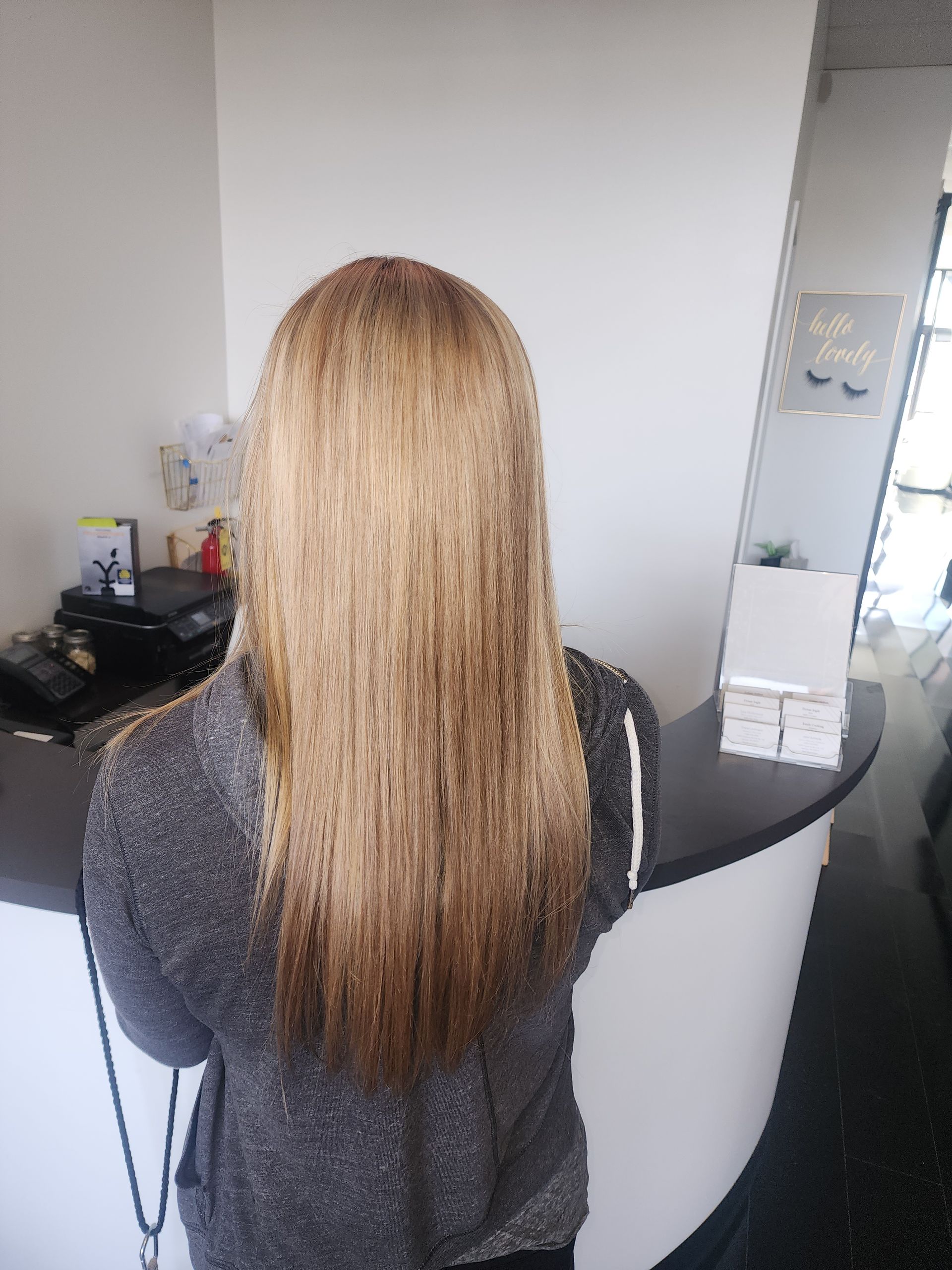 A woman with long blonde hair is standing in front of a counter.