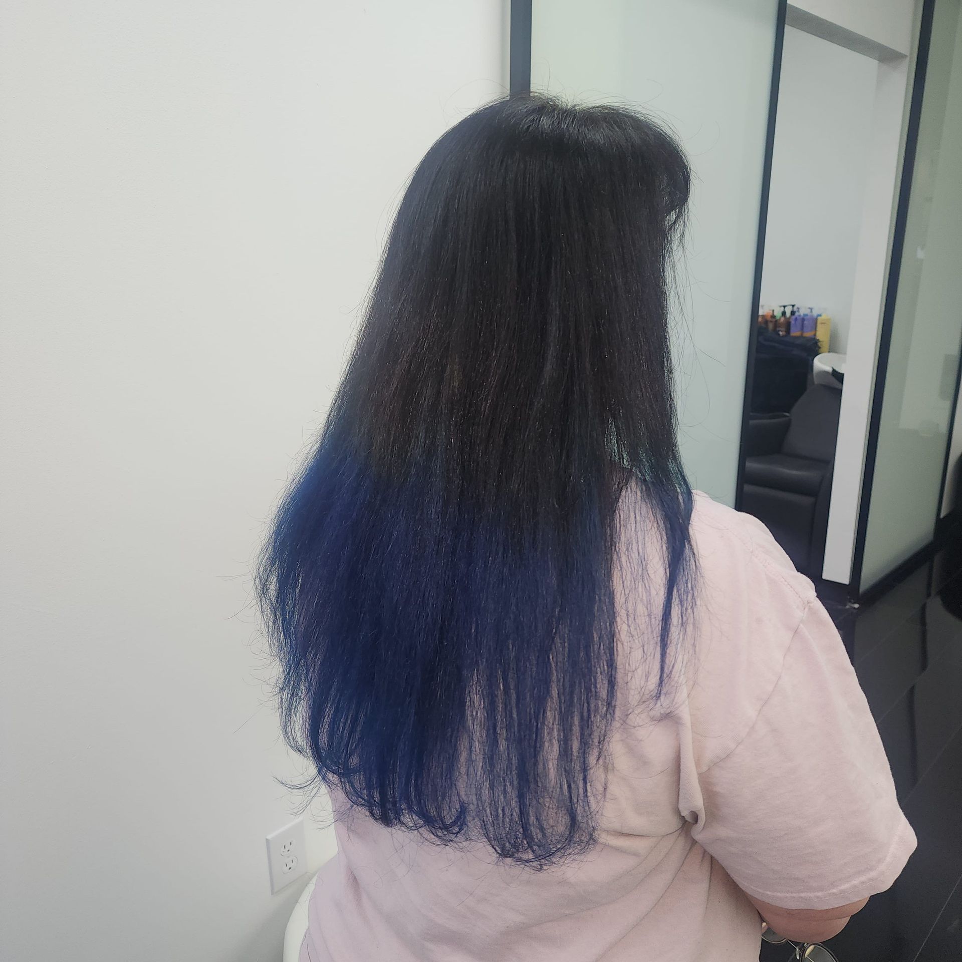 A woman with long black hair with blue highlights