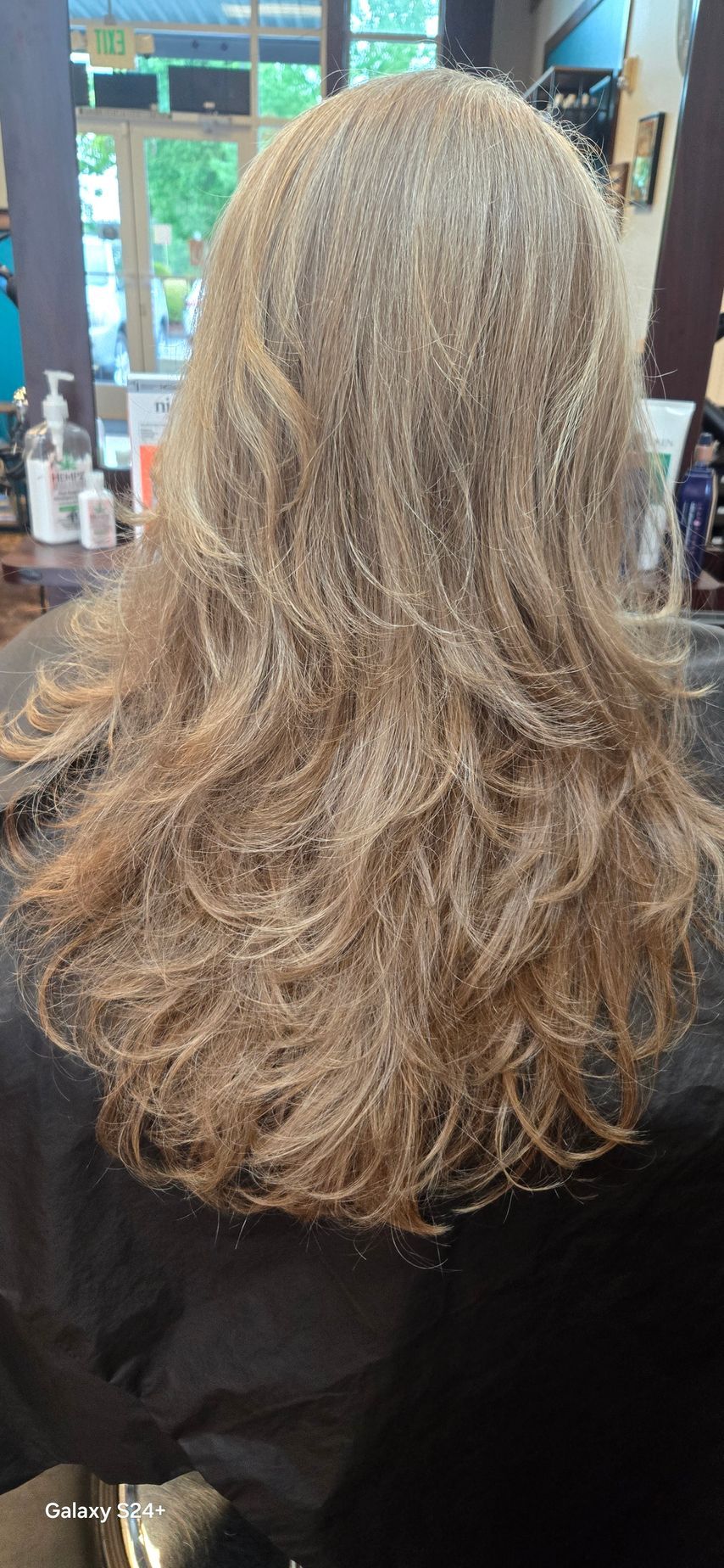 A woman is getting her hair cut in a salon.