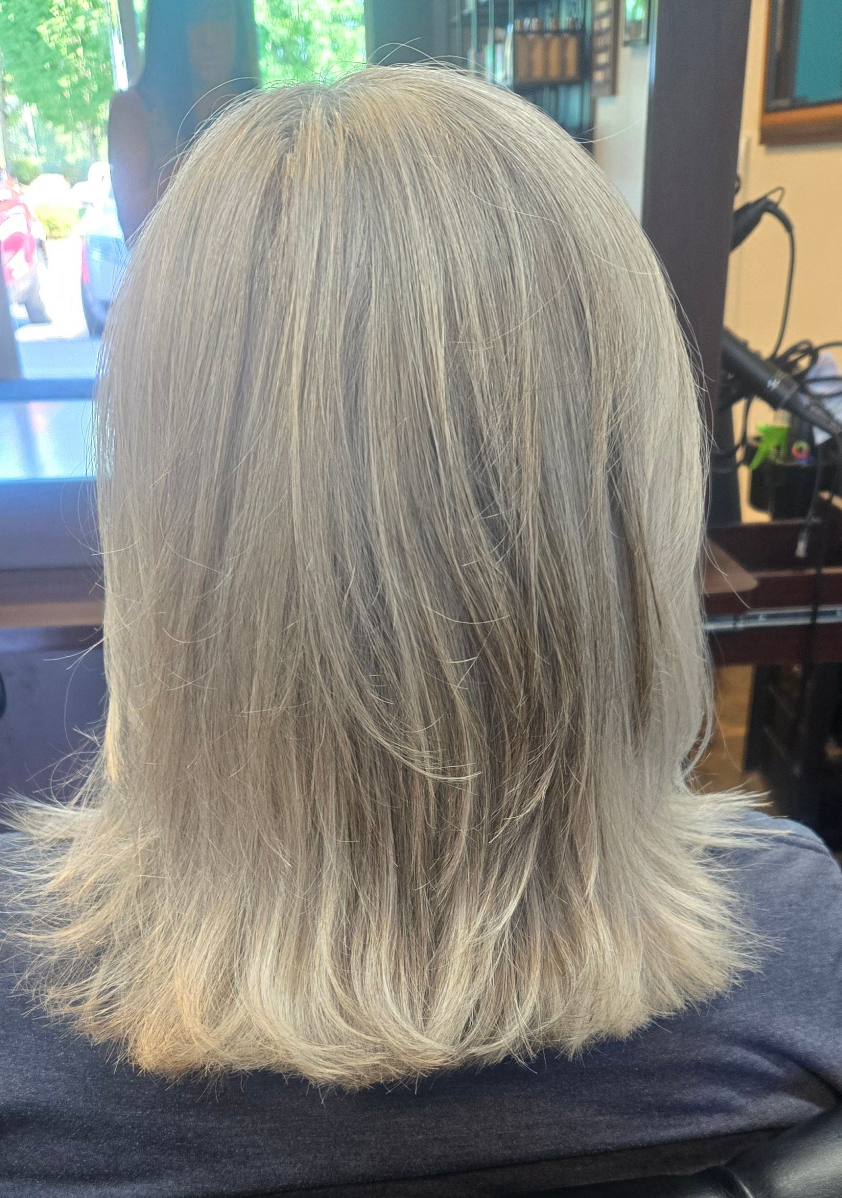 The back of a woman 's hair is shown in a salon.