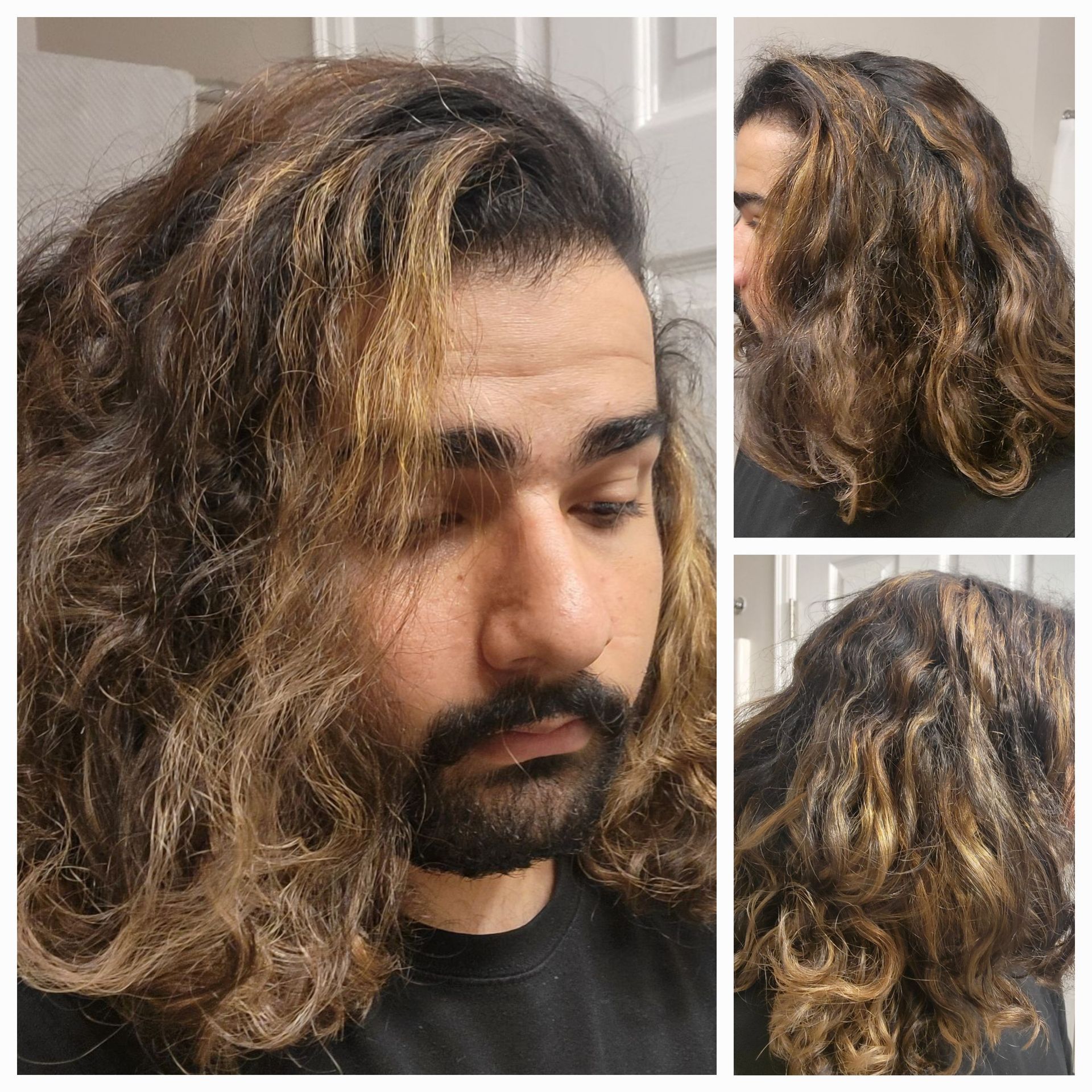 A man with long curly hair and a beard is wearing a black shirt.