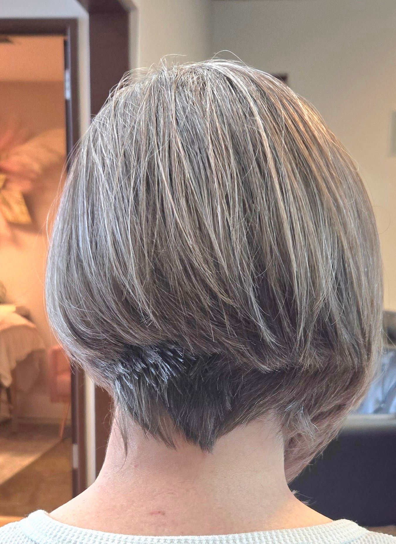 The back of a woman 's head with short gray hair.