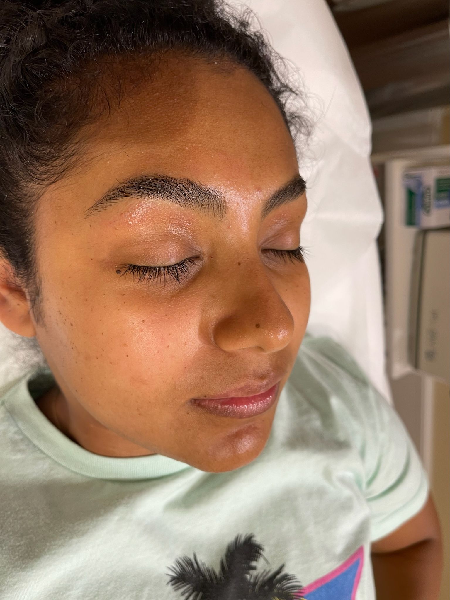 A woman is laying in a hospital bed with her eyes closed.