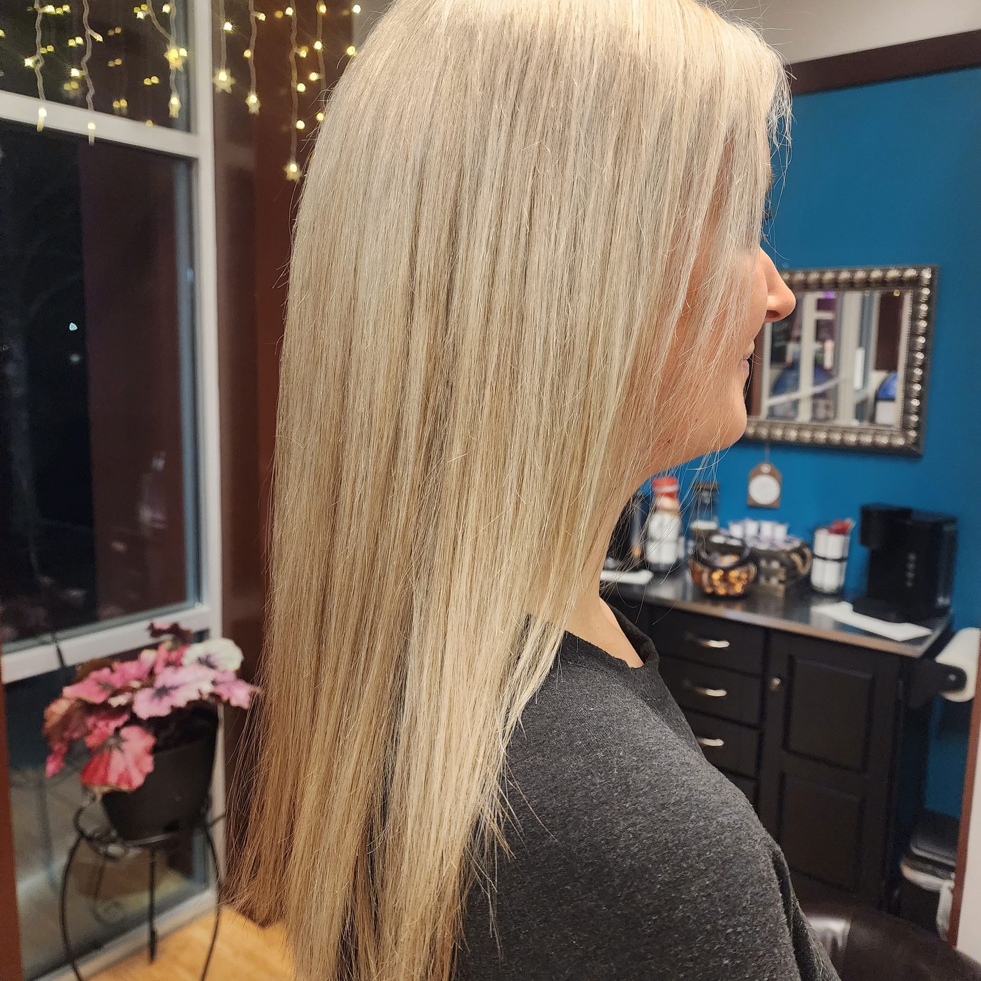 A woman with blonde hair is standing in front of a window