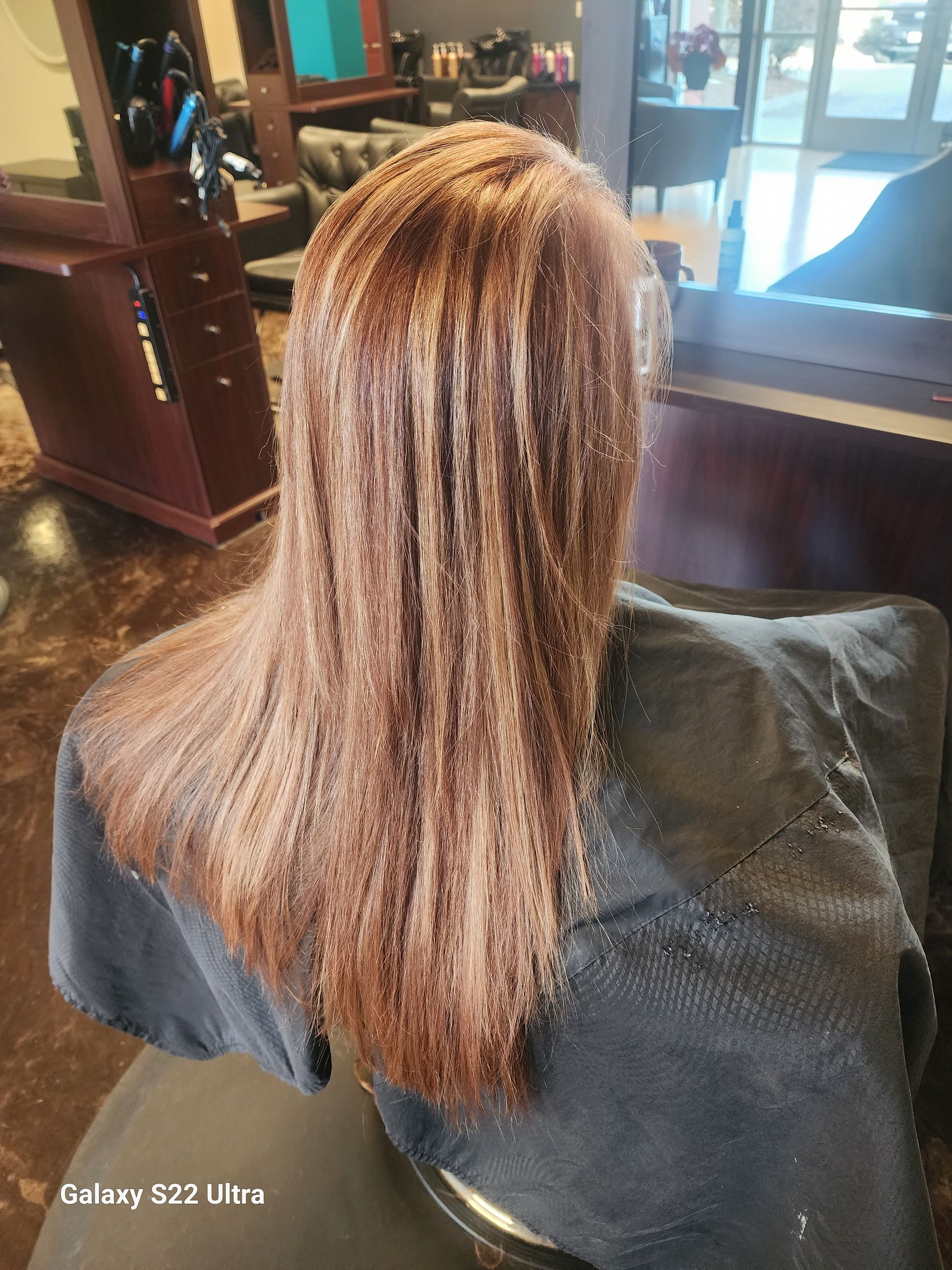 A woman is getting her hair cut in a salon.