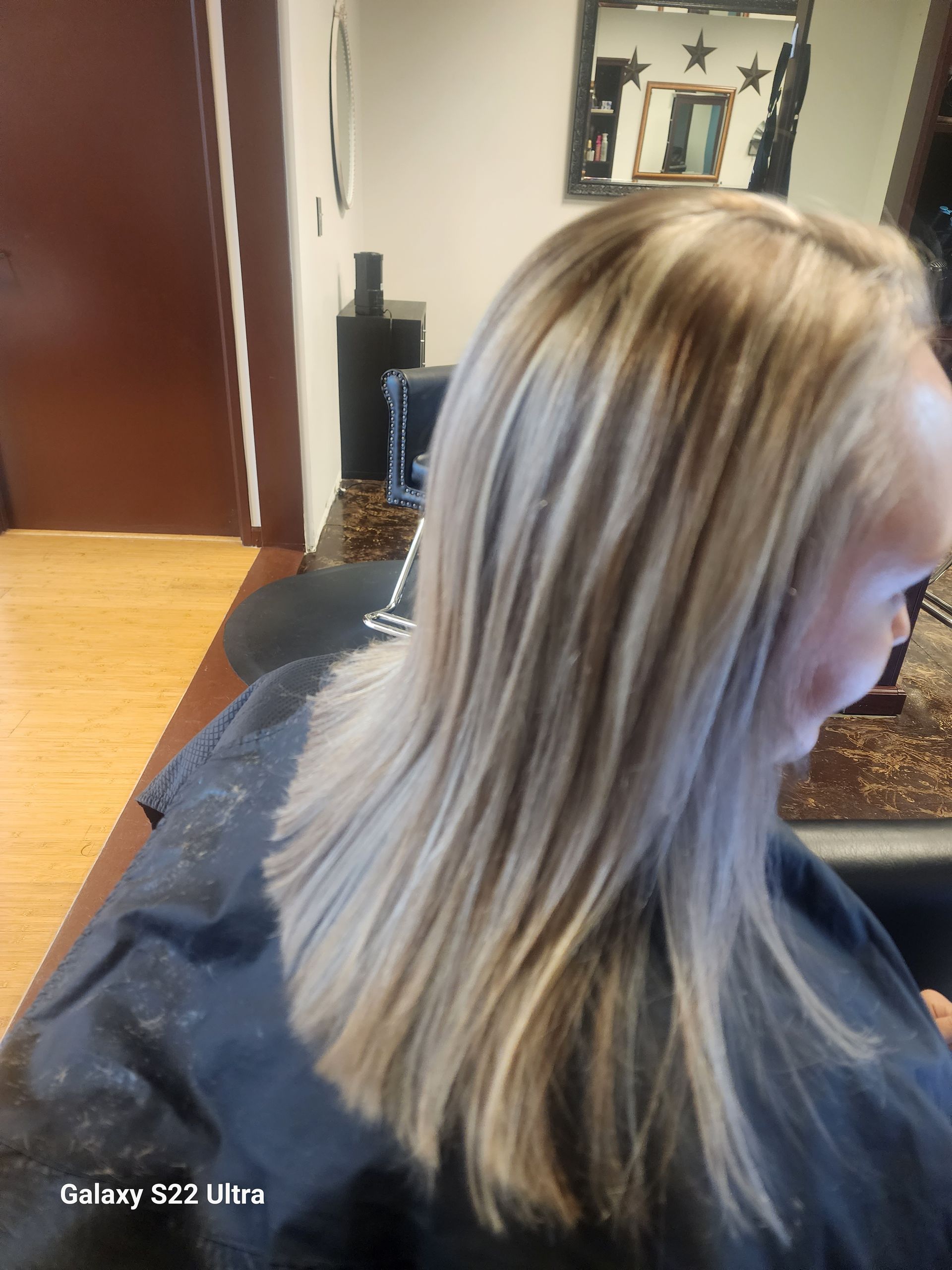 A woman is getting her hair cut in a salon.