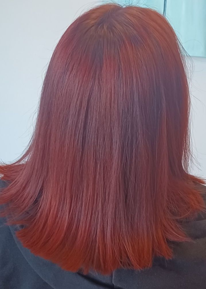 A woman with red hair is wearing a black hoodie.