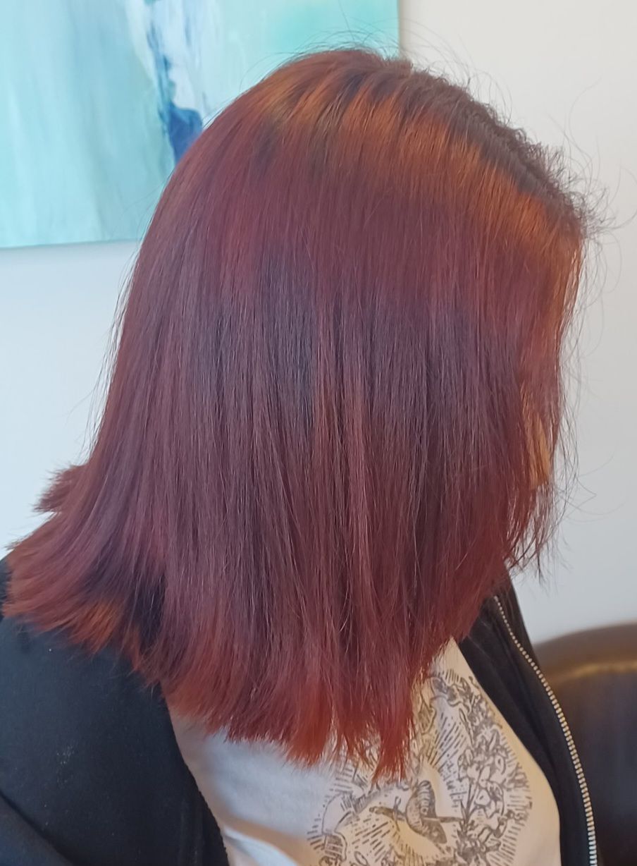 A woman with red hair is wearing a black jacket