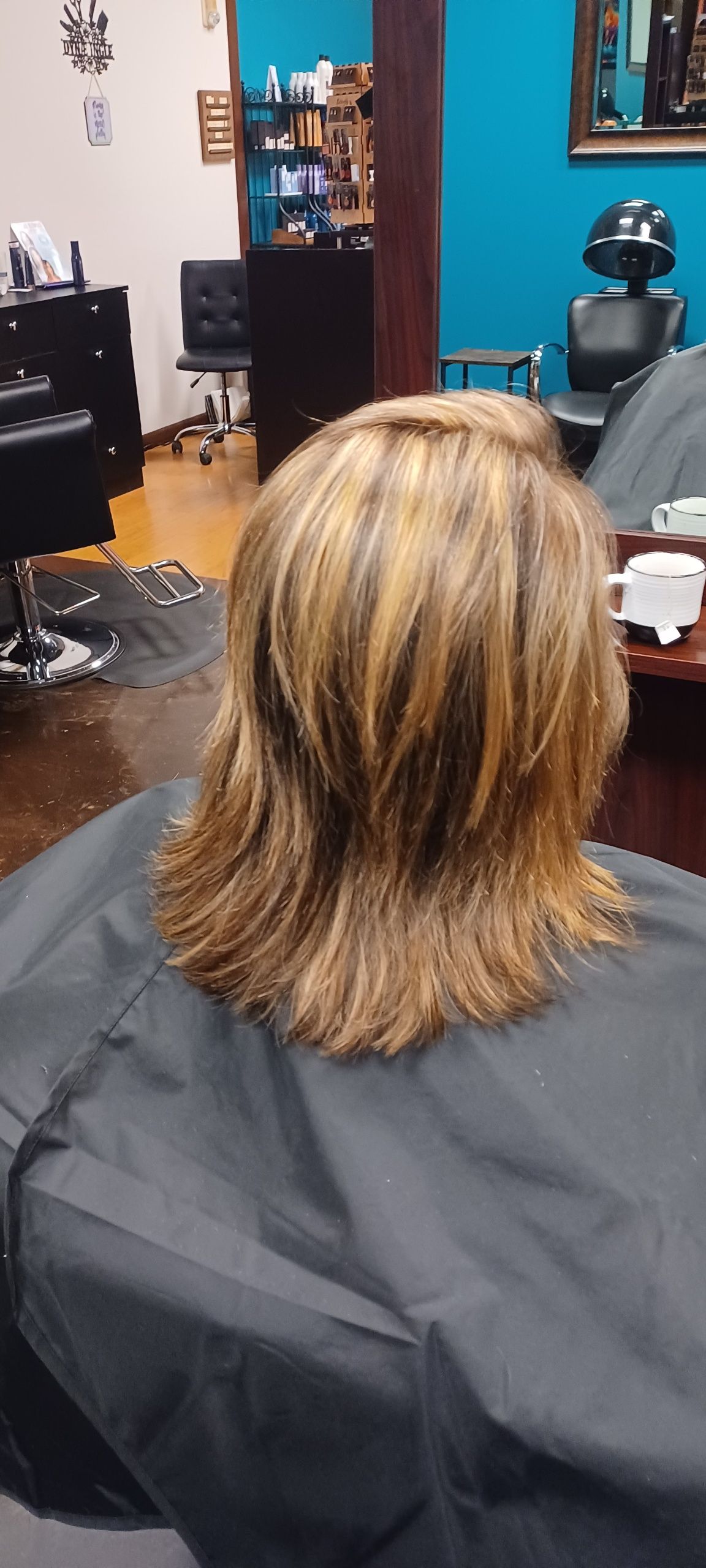 A woman is getting her hair cut in a salon.