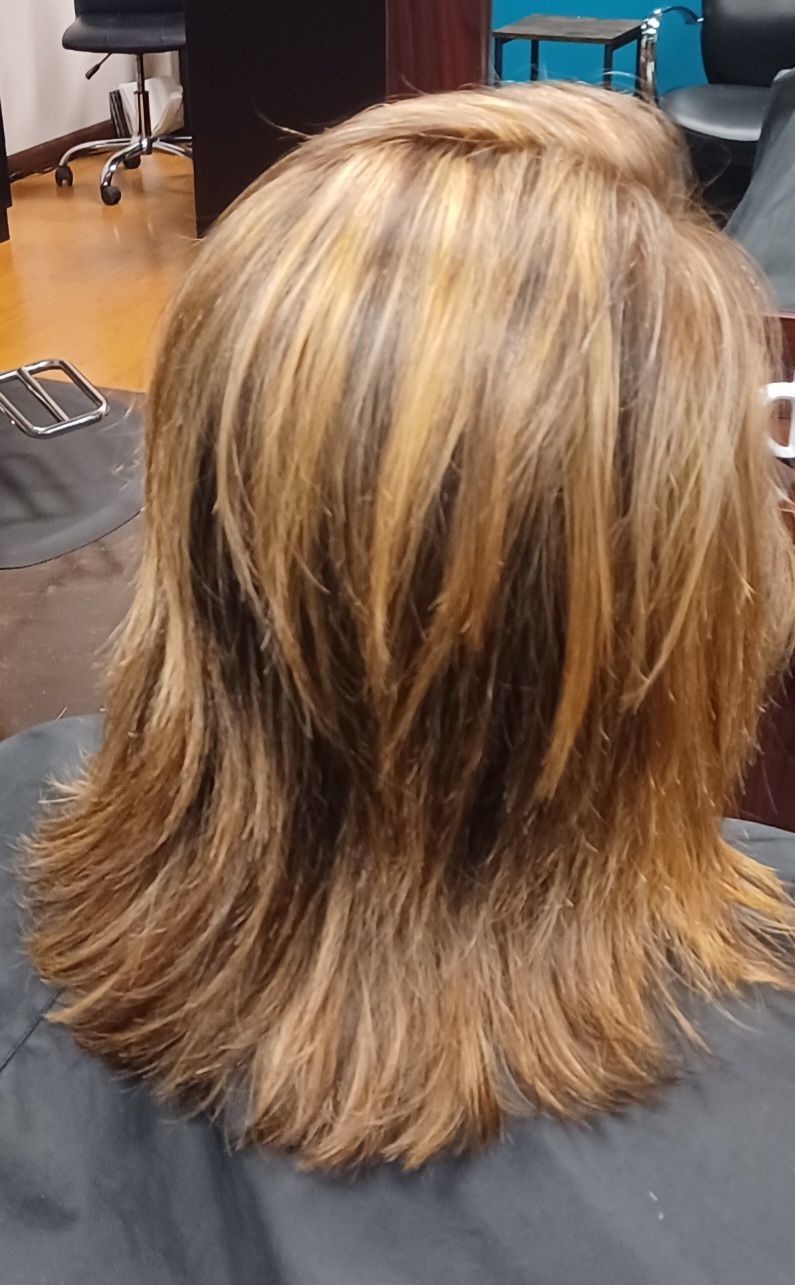 A woman is getting her hair cut in a salon.
