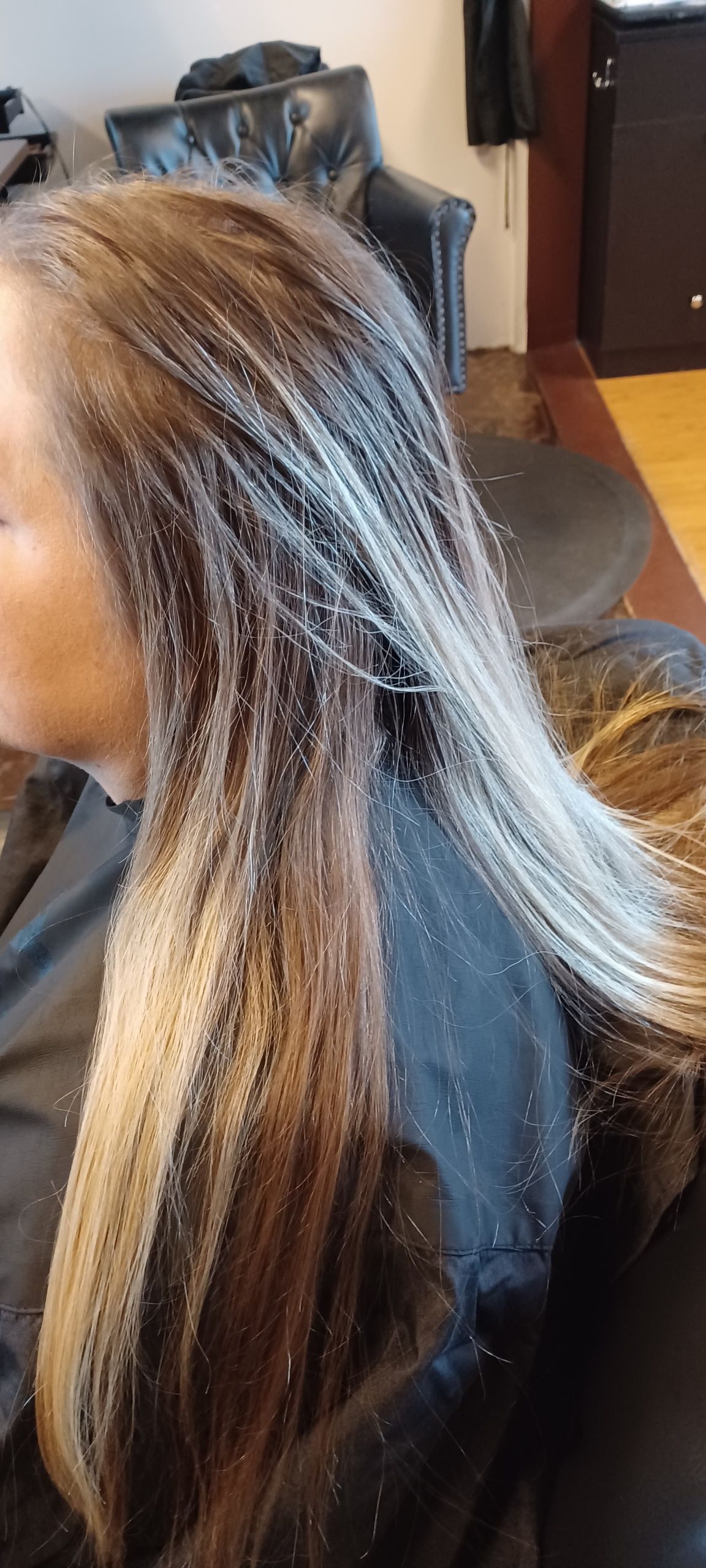 A woman is getting her hair dyed in a salon.