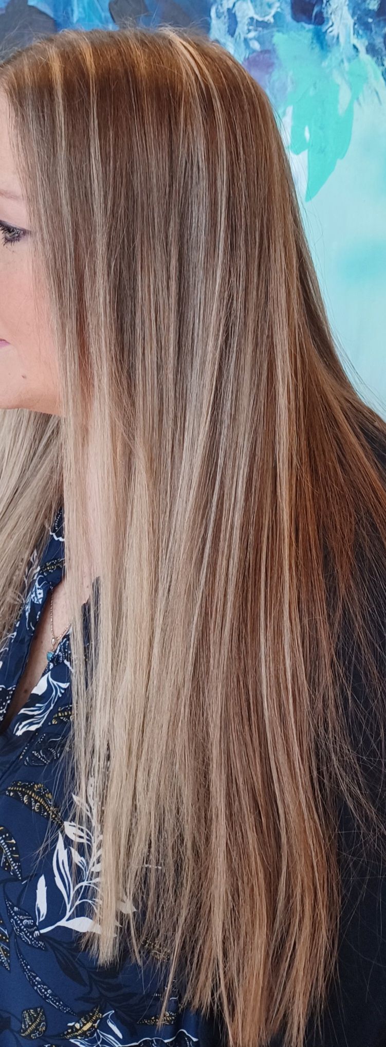 A close up of a woman 's hair with a painting in the background.