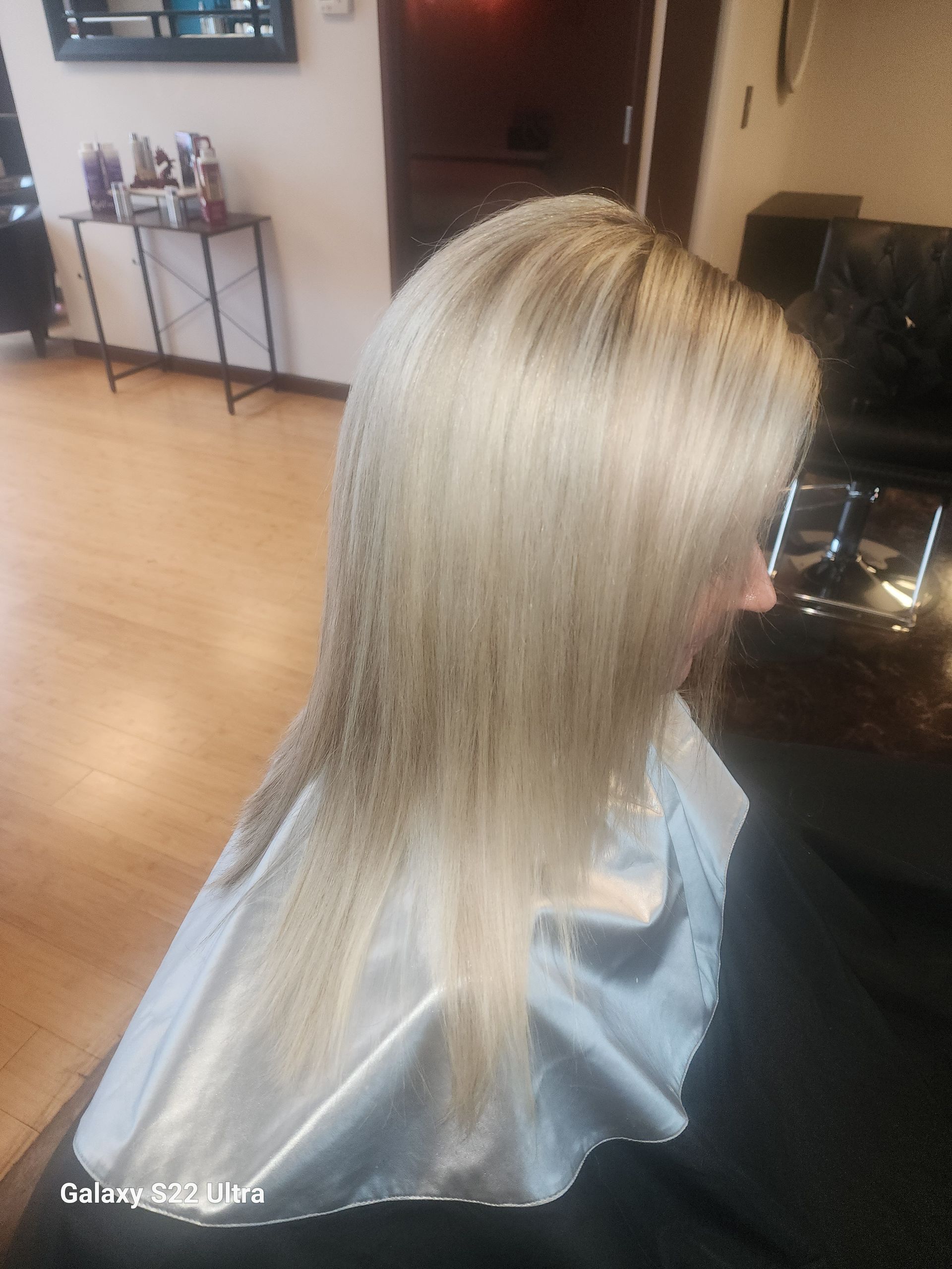 A woman is getting her hair cut in a salon.