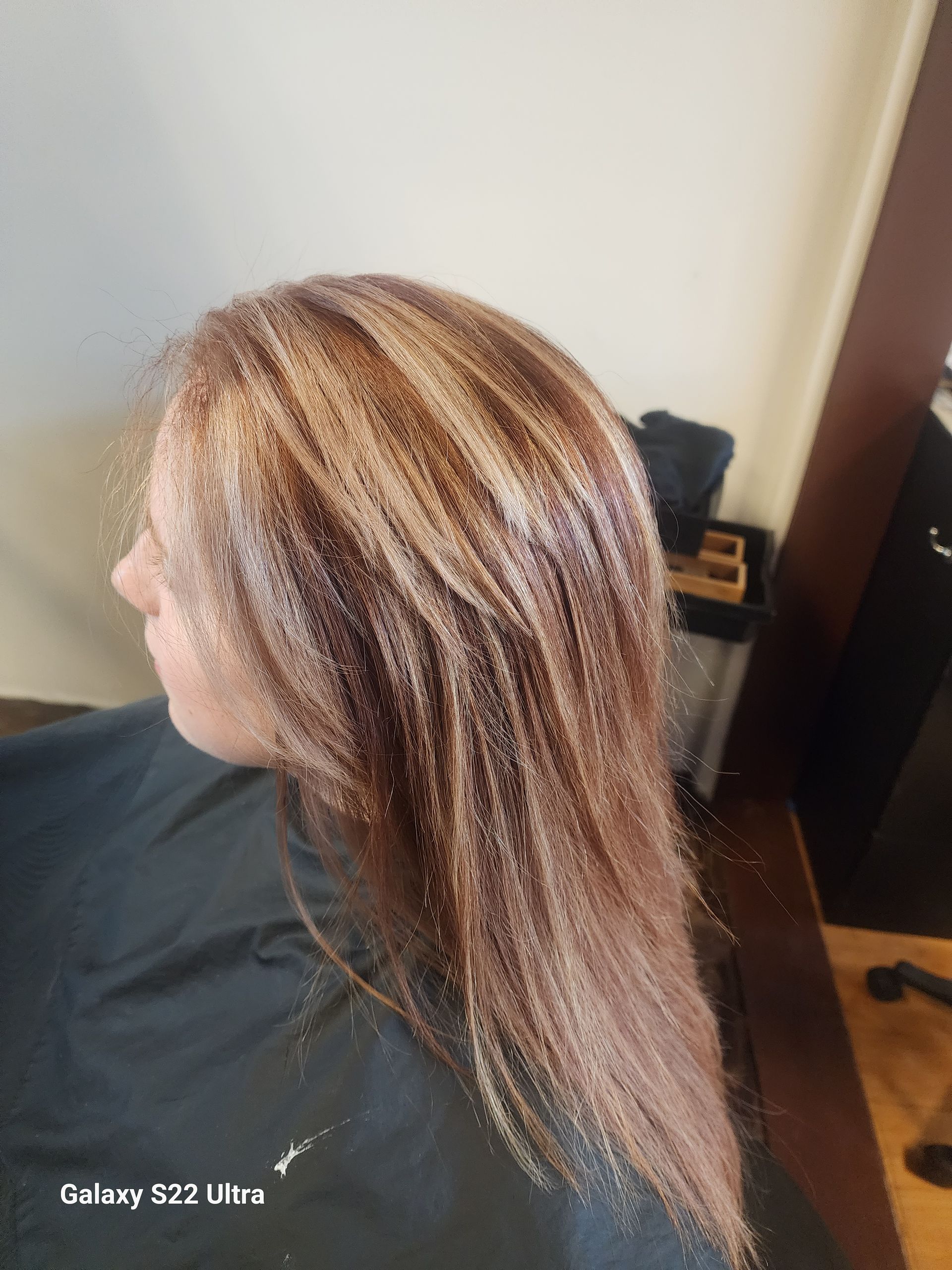 A woman is sitting in a chair with her hair covered in glitter.