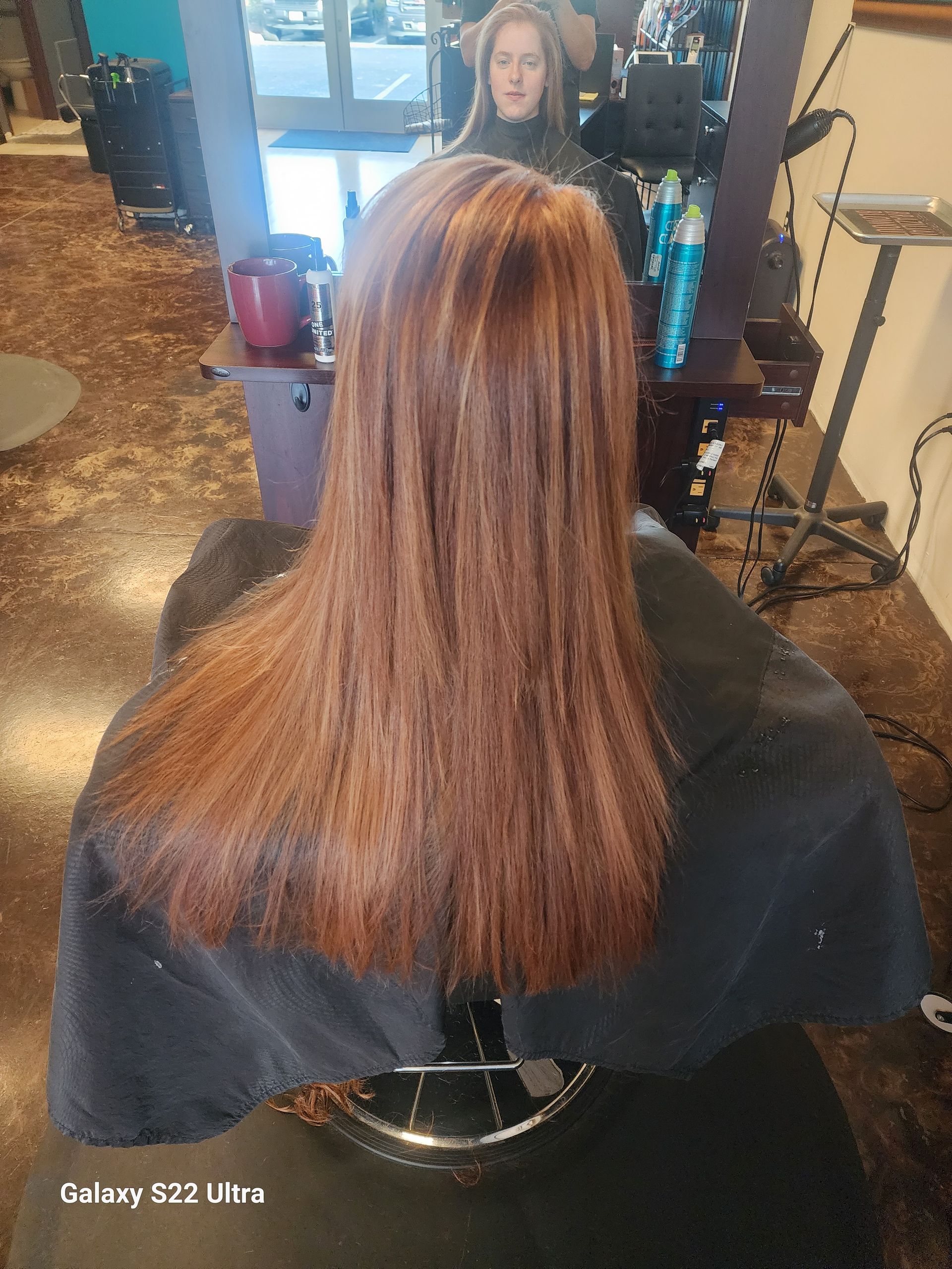 A woman is getting her hair cut in a salon.
