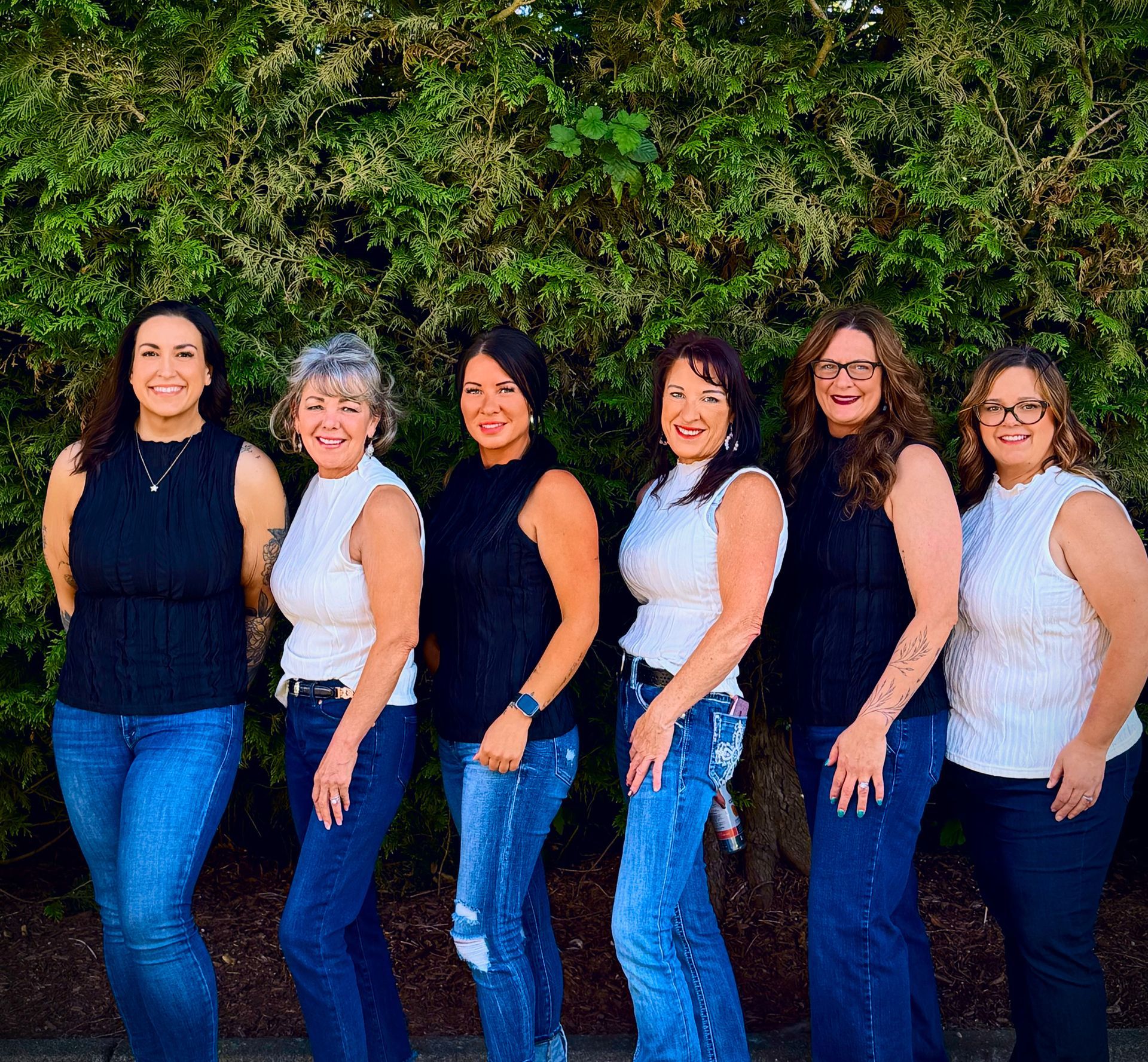A woman with long brown hair is standing in a parking lot.