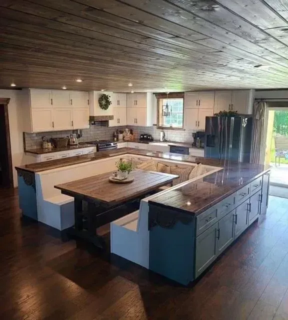 Open-concept kitchen with dark wood floors, large island, white cabinets, and vaulted wood ceiling