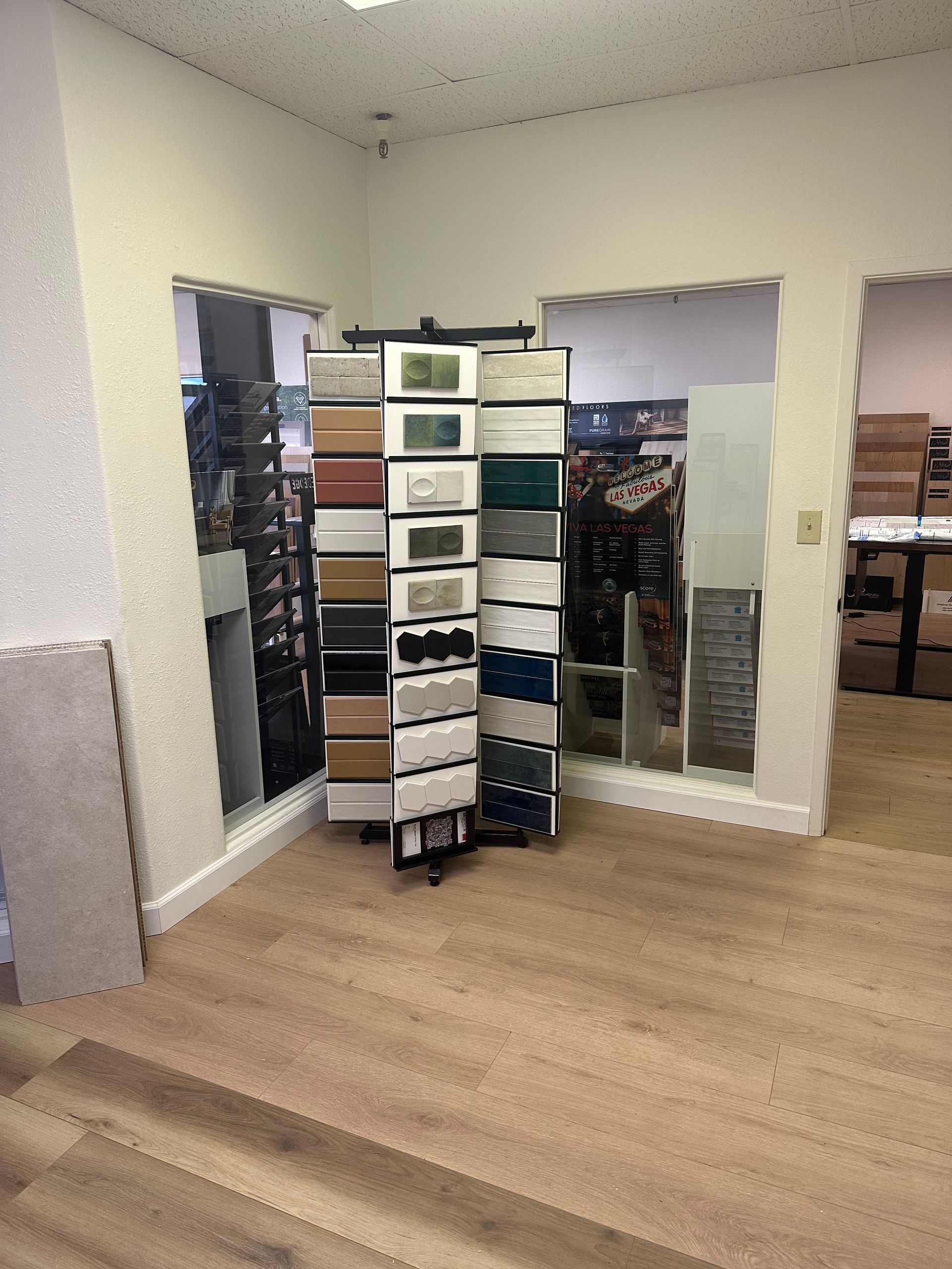 A showroom with floor samples, tile displays, and three doorways with views to the rest of the store.