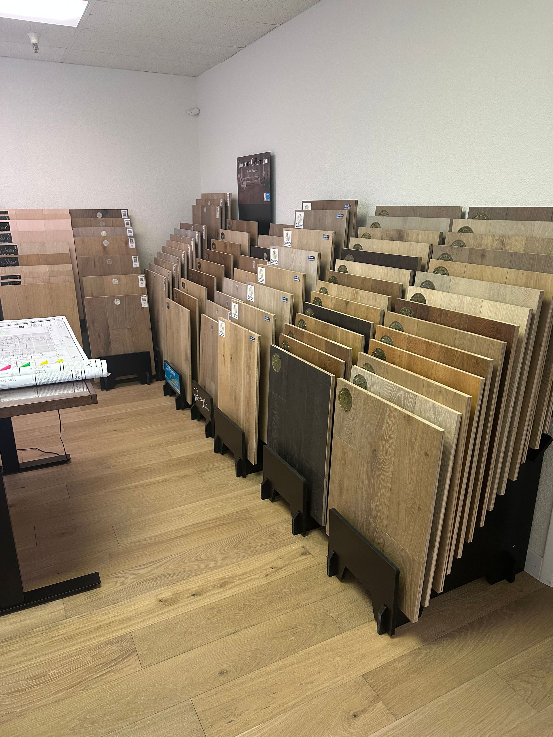 Tile samples displayed in a showroom. Various colors and textures on wood floors.