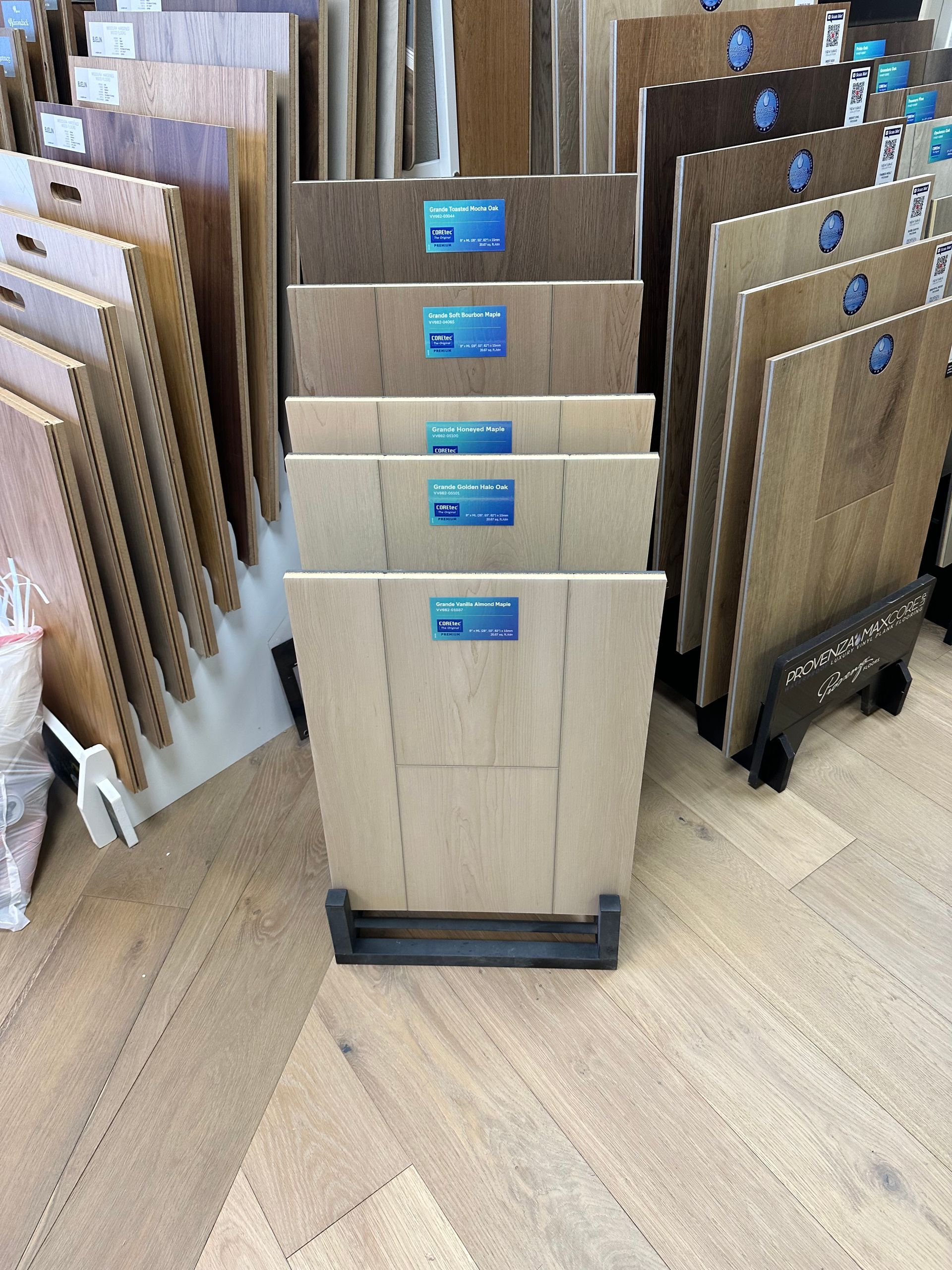 Display of various wood flooring samples in a store, showcasing different colors and textures.