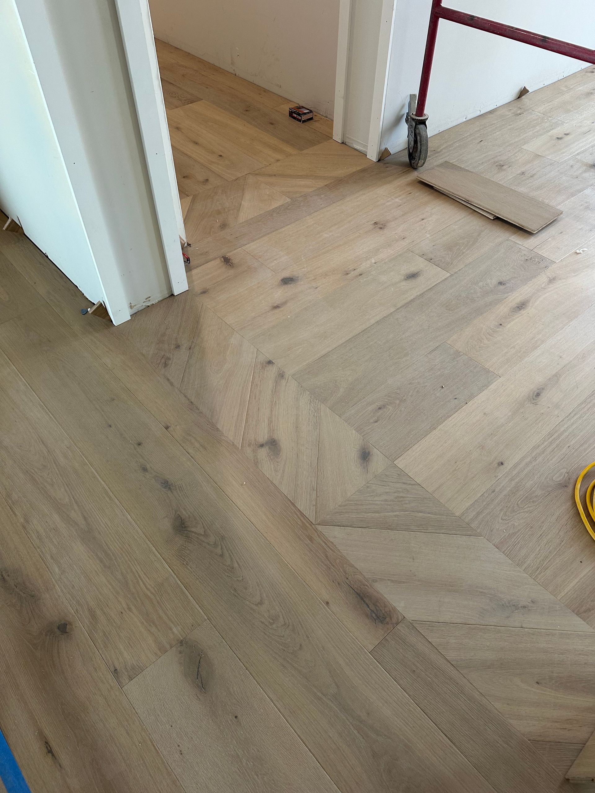 Herringbone pattern wood floor with doorway.