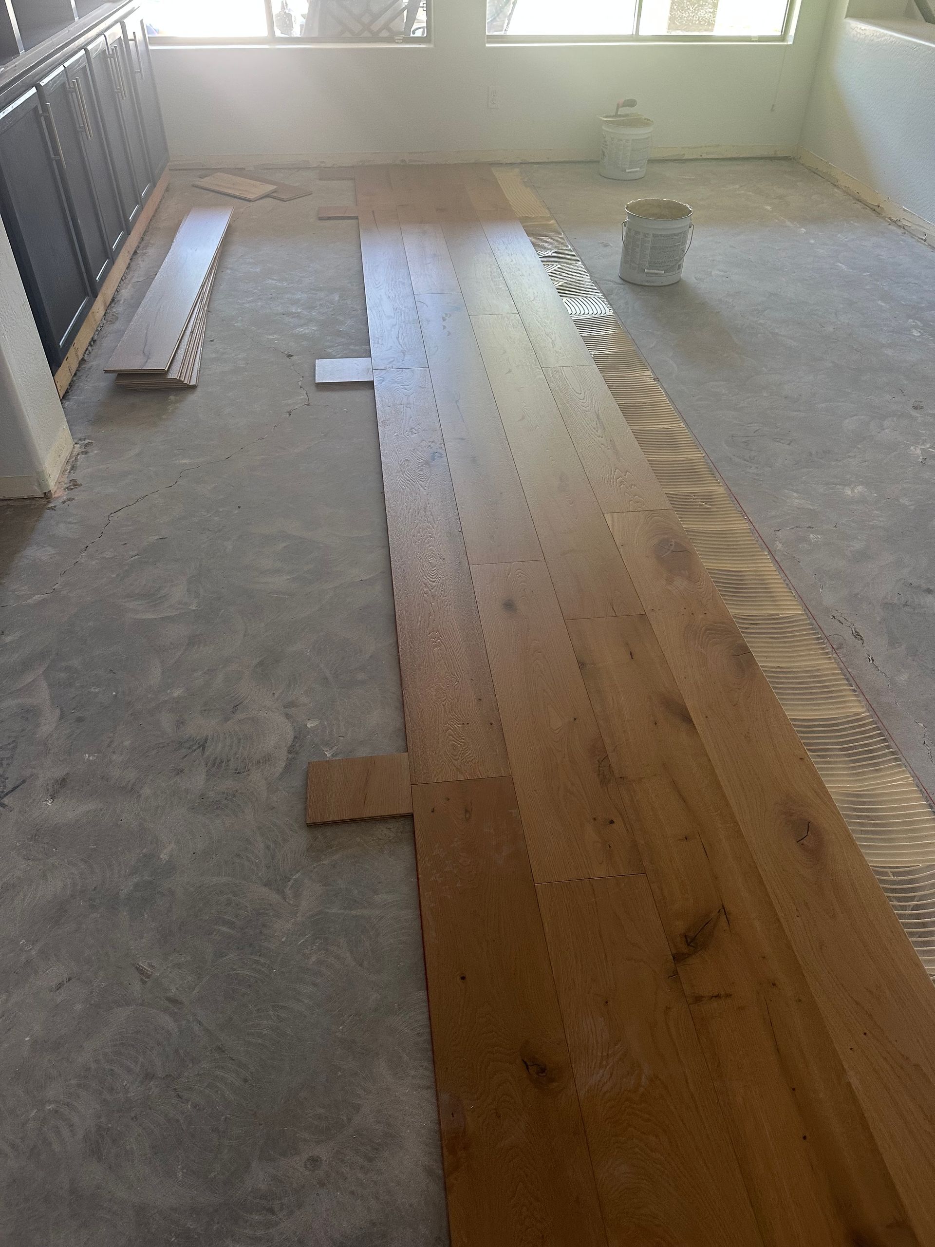 Wooden flooring being installed on a concrete floor.