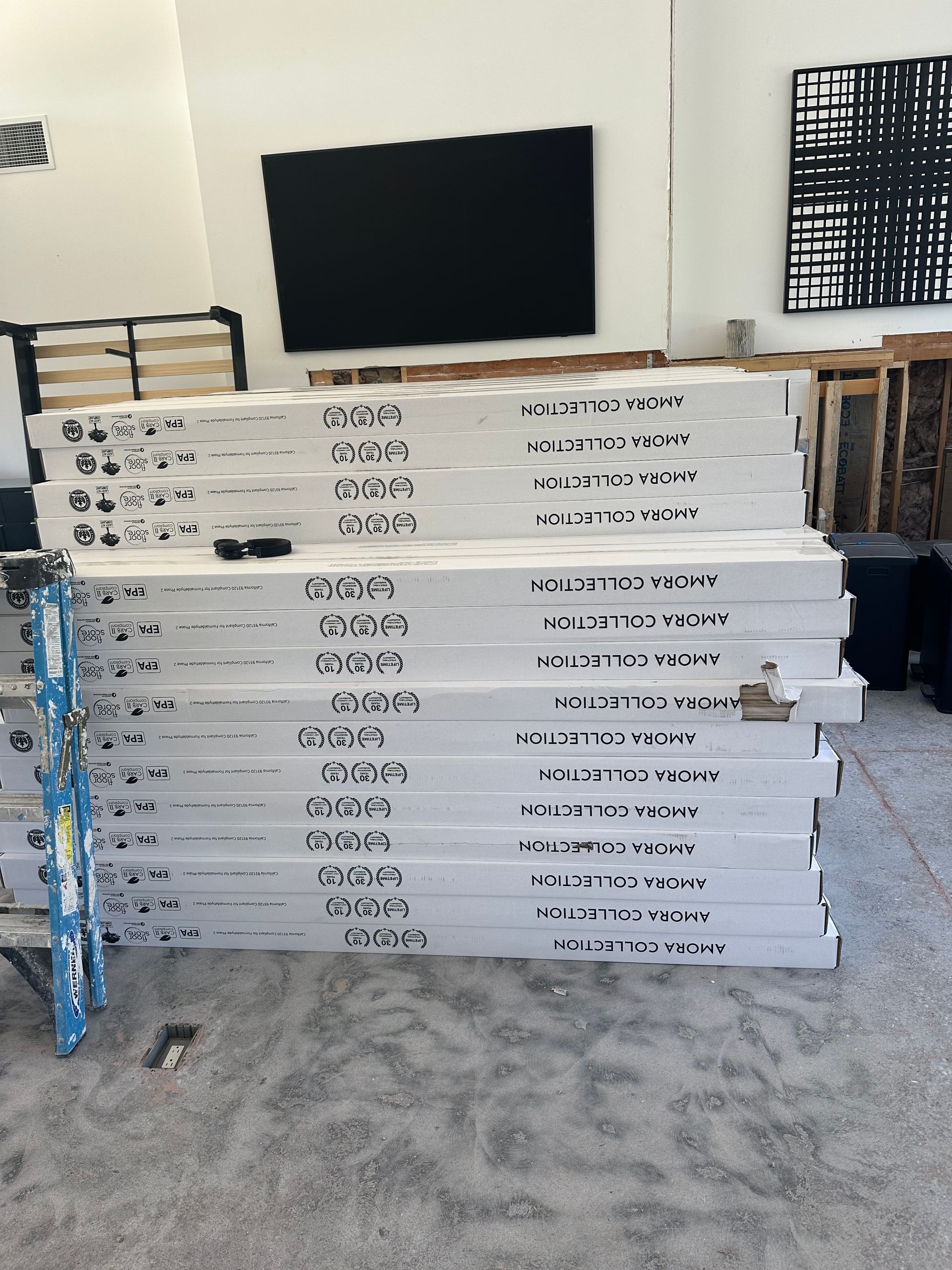 Stack of white door frames labeled with black text in a warehouse.