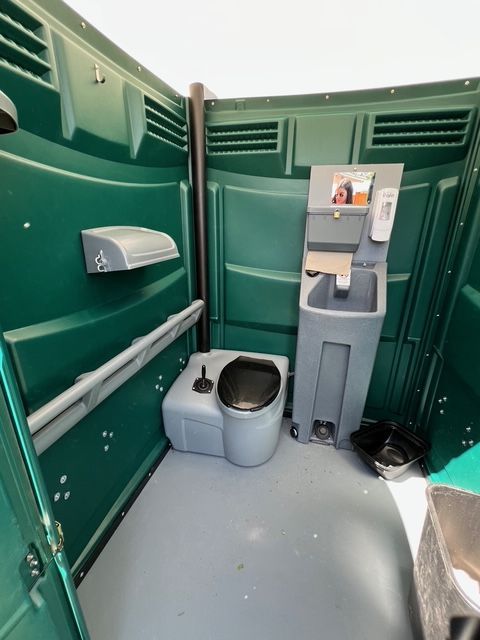 Orange portable toilets with a Packerland Portables logo.