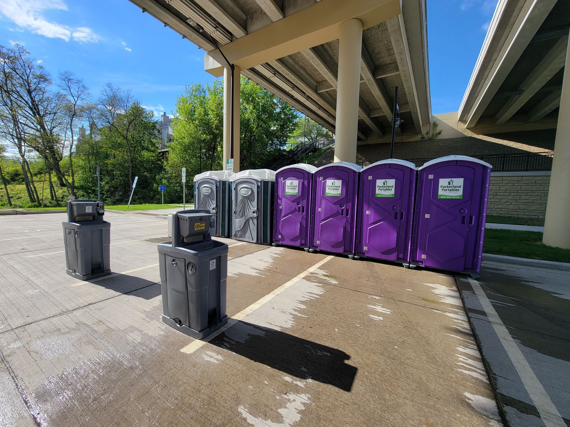 Orange portable toilets with a Packerland Portables logo.