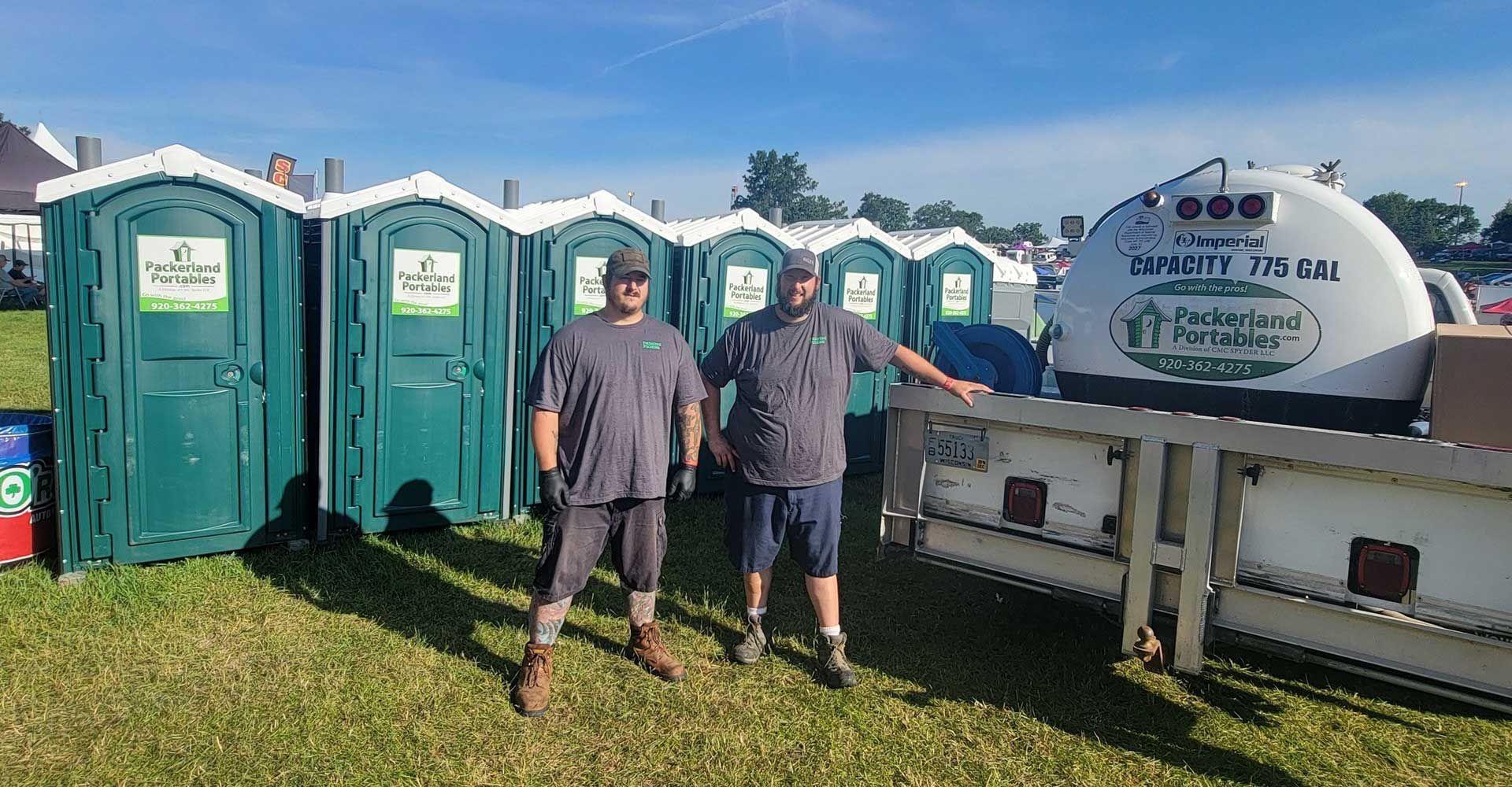 Gray portable toilet with Packerland Portables logo and ADA symbol.