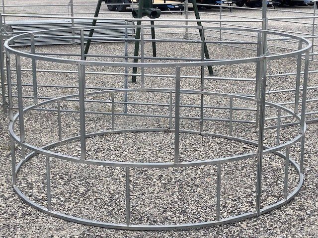 A metal fence is sitting on top of a gravel ground.