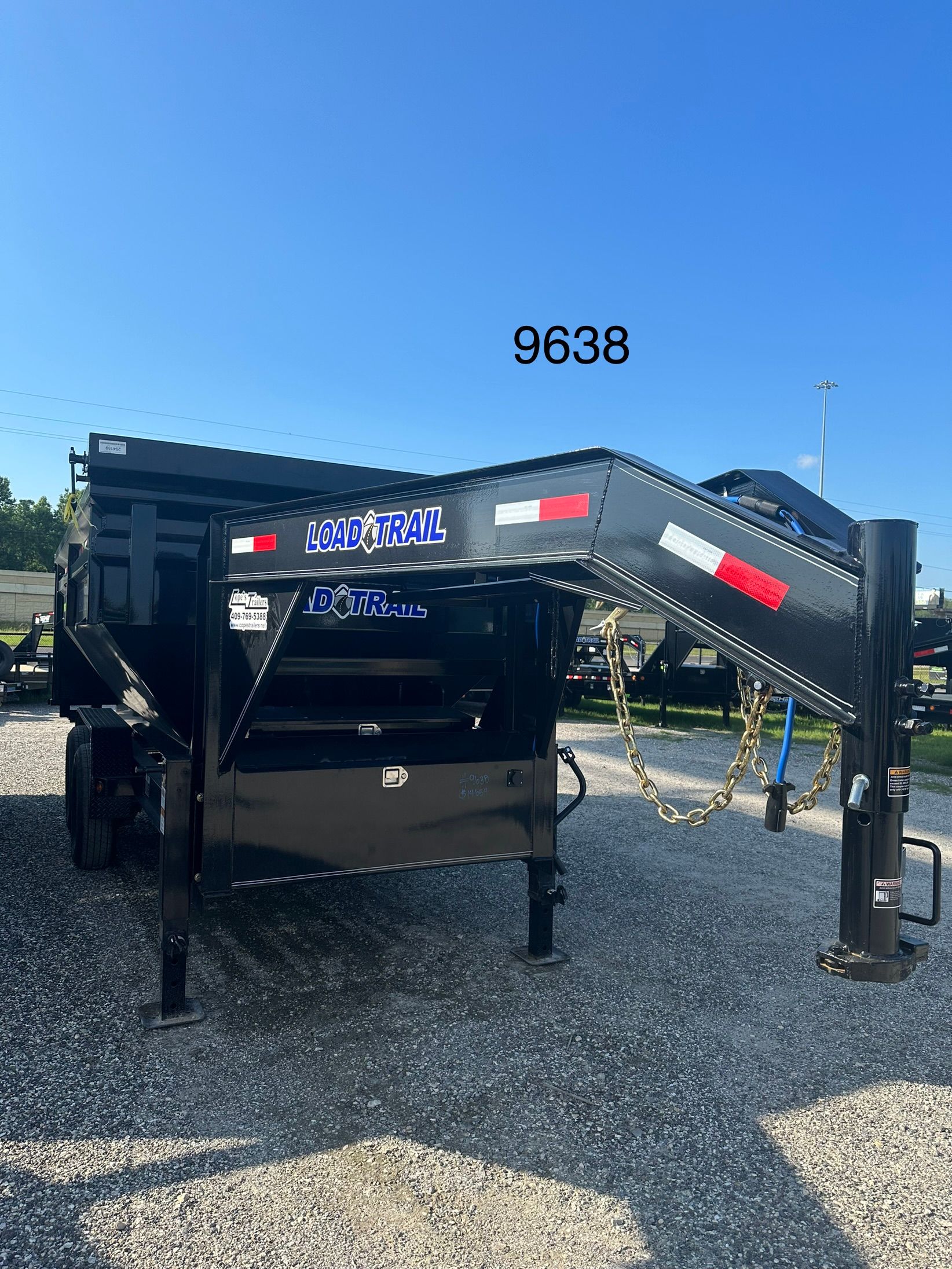 A dump truck is parked in a gravel lot.
