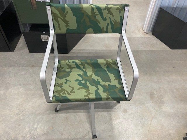 A green camouflage chair is sitting on a concrete floor