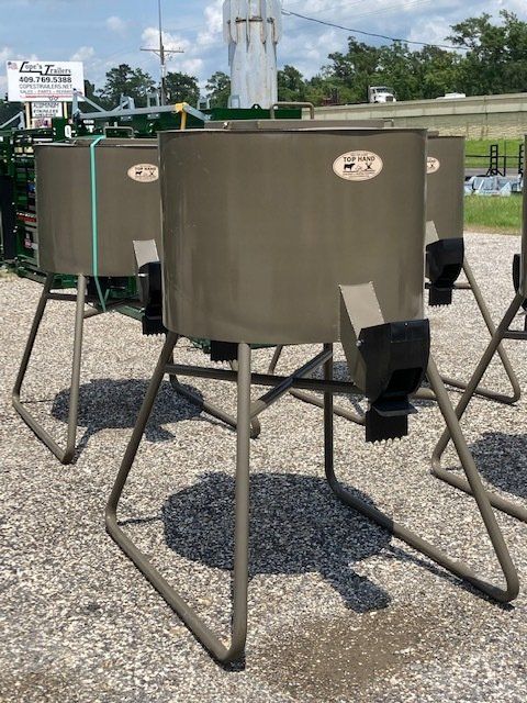 A group of feeders are sitting on top of a gravel road.
