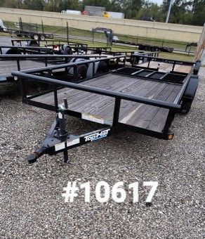 Black utility trailer with wooden deck on gravel, with a number 10617 in white text.