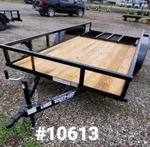 Black utility trailer with wooden deck, black railing, and black hitch, parked outside.
