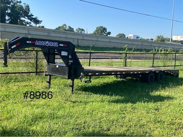 black gooseneck trailer on a grassy area 