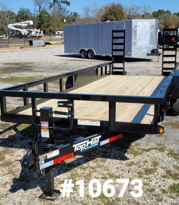 Black Top Hat utility trailer on a lot with an enclosed trailer in the background.