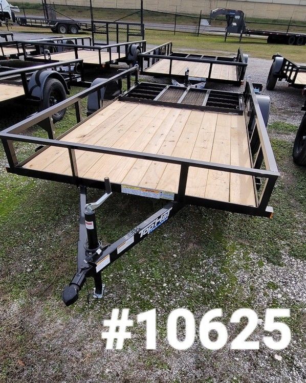 Black utility trailer with wooden deck, black railing, and hitch.