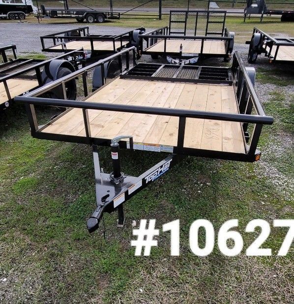 Black utility trailer with wooden deck, grassy setting, and number #10627 in white.