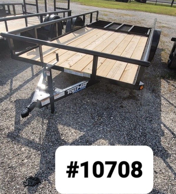 A black metal utility trailer with a wooden floor and a hitch, parked on a gravel lot, labeled with the number #10708.