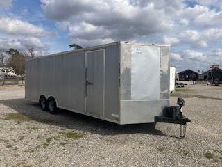 Aluminum enclosed trailer on gravel lot, overcast sky.