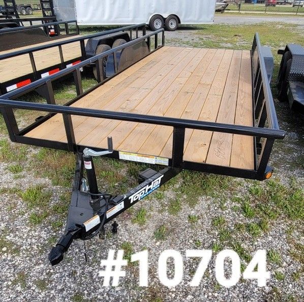 A black utility trailer with wooden floorboards parked on gravel, marked with the number 10704.