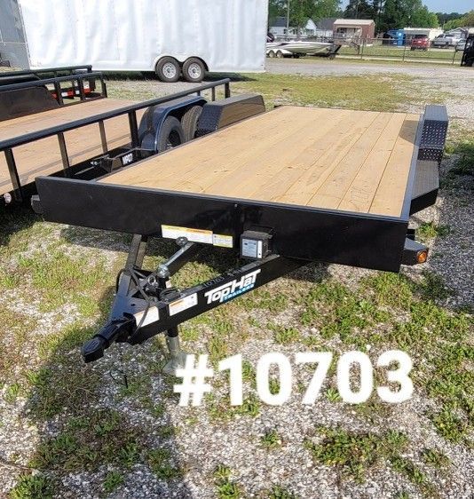 A black Top Hat utility trailer with a wooden deck parked on a gravel lot, labeled with the number 10703.