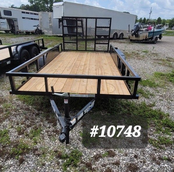 Wooden utility trailer with black metal rails, front hitch, and number 10748 in a gravel lot.